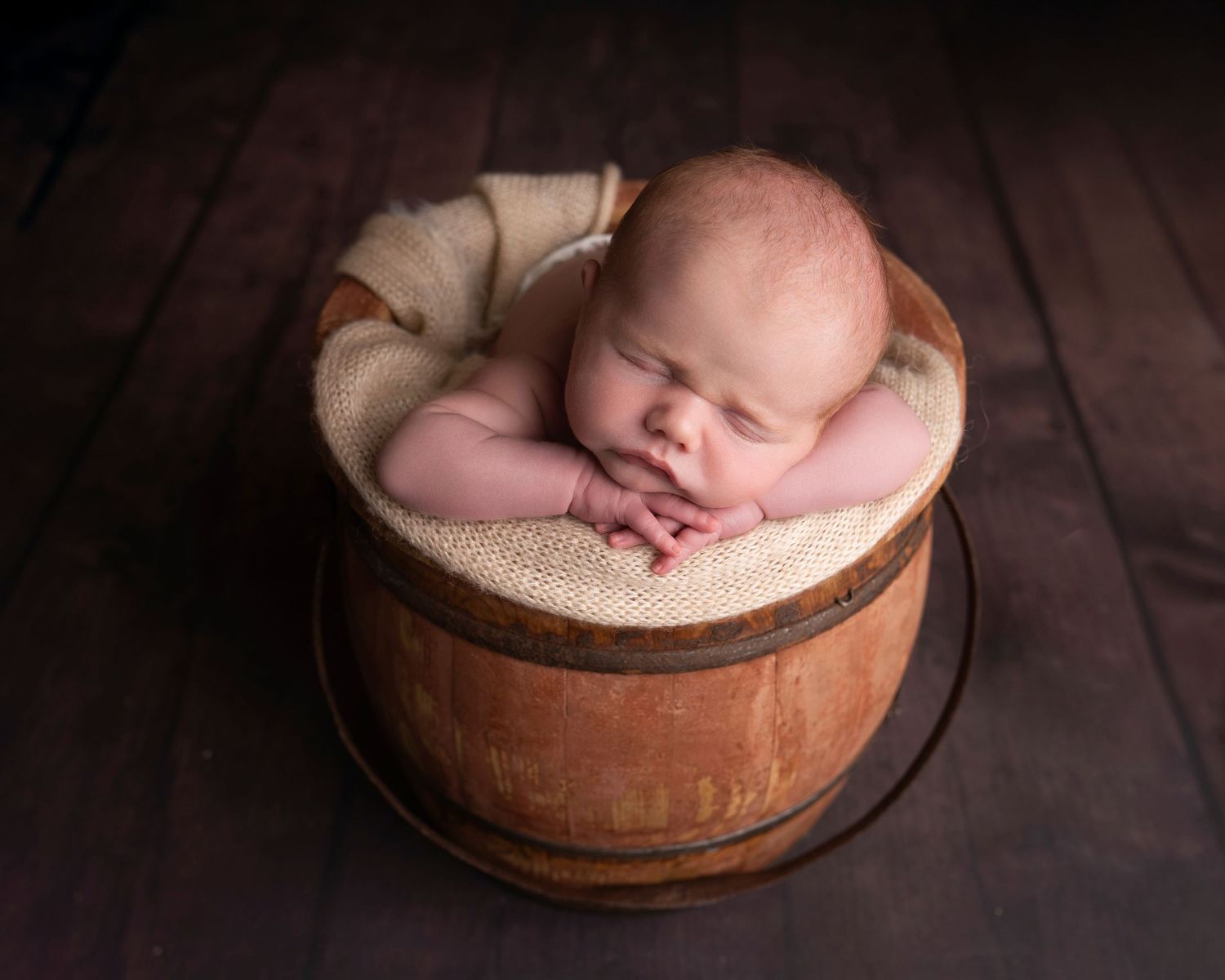Baby boy in bucket chin on hands photographed by bcapture photography in swansea
