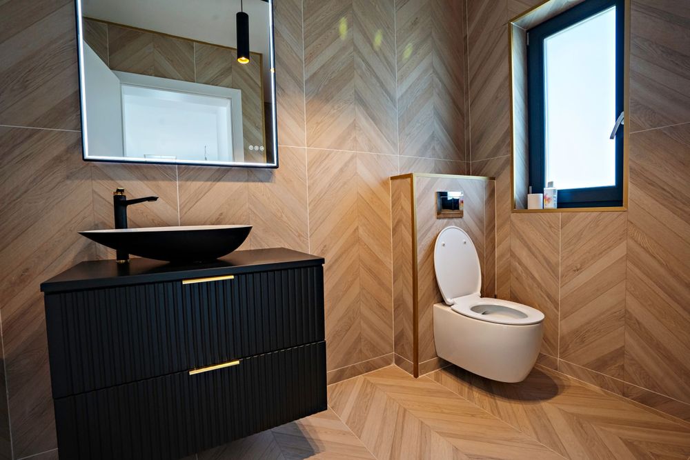 Minimalist bathroom design featuring black floating vanity and herringbone wood-look tile.