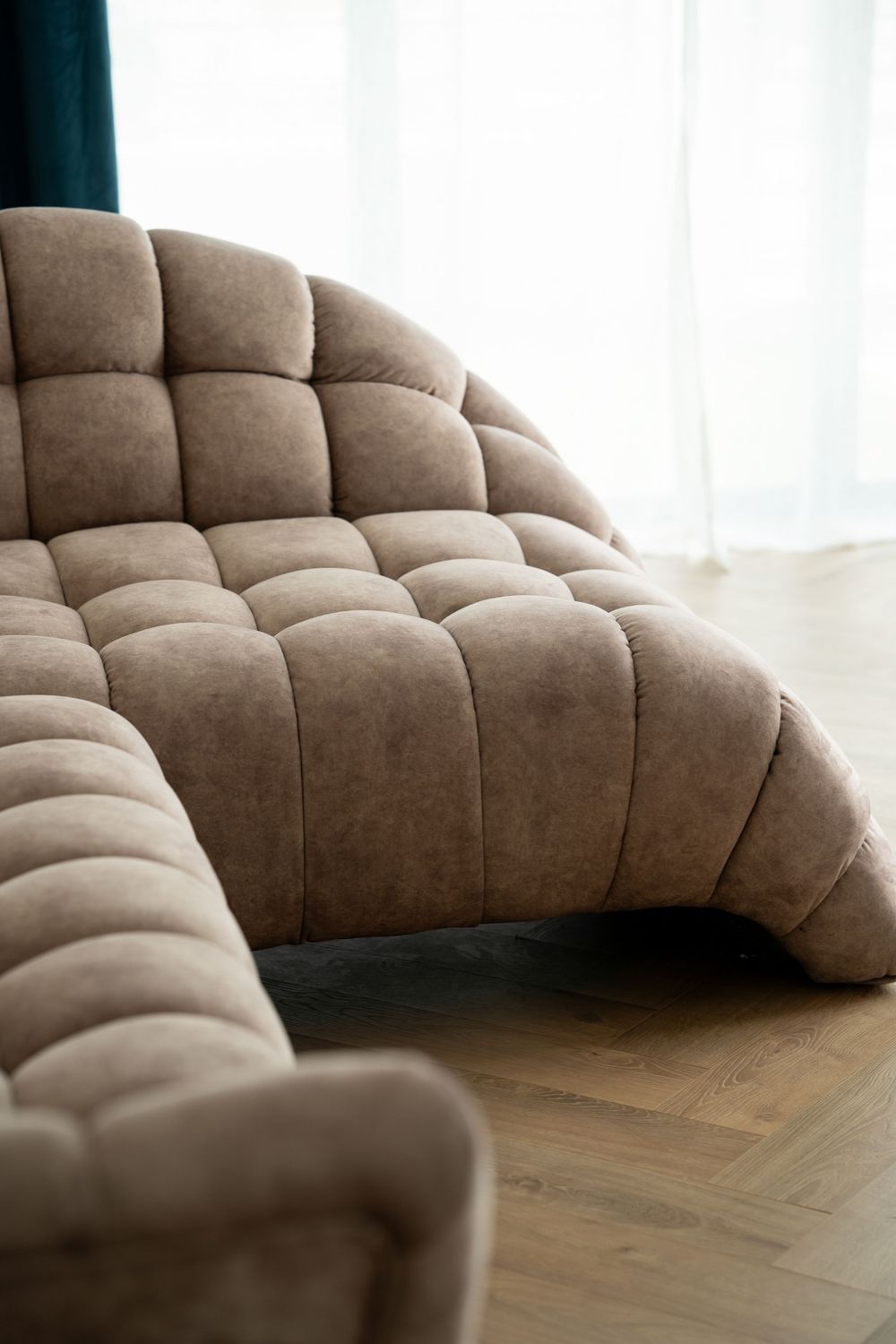 Plush beige modular sofa with tufted cushioning creates a luxurious seating arrangement on hardwood flooring.