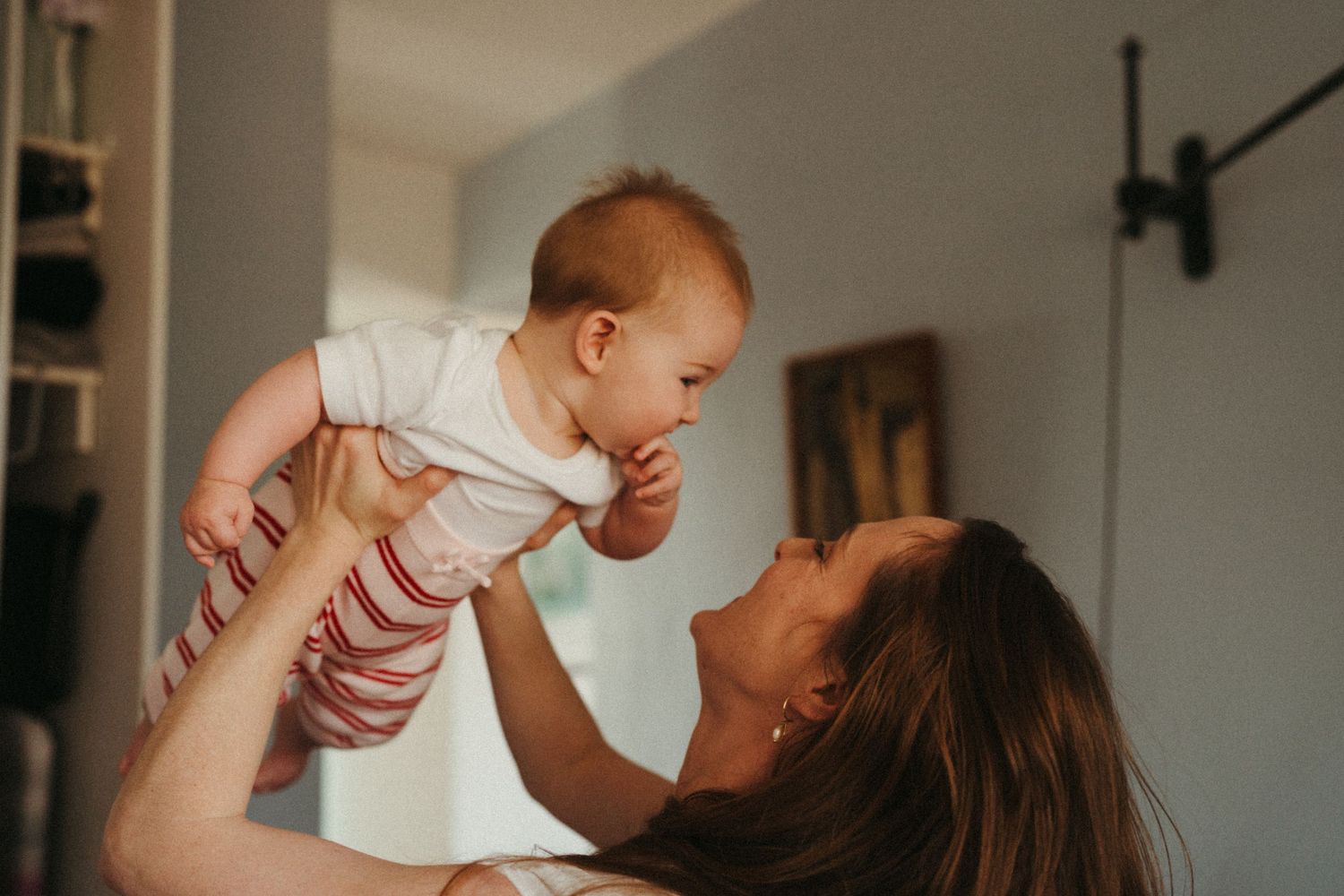 Candid indoor family moment showing joyful interaction in natural light.