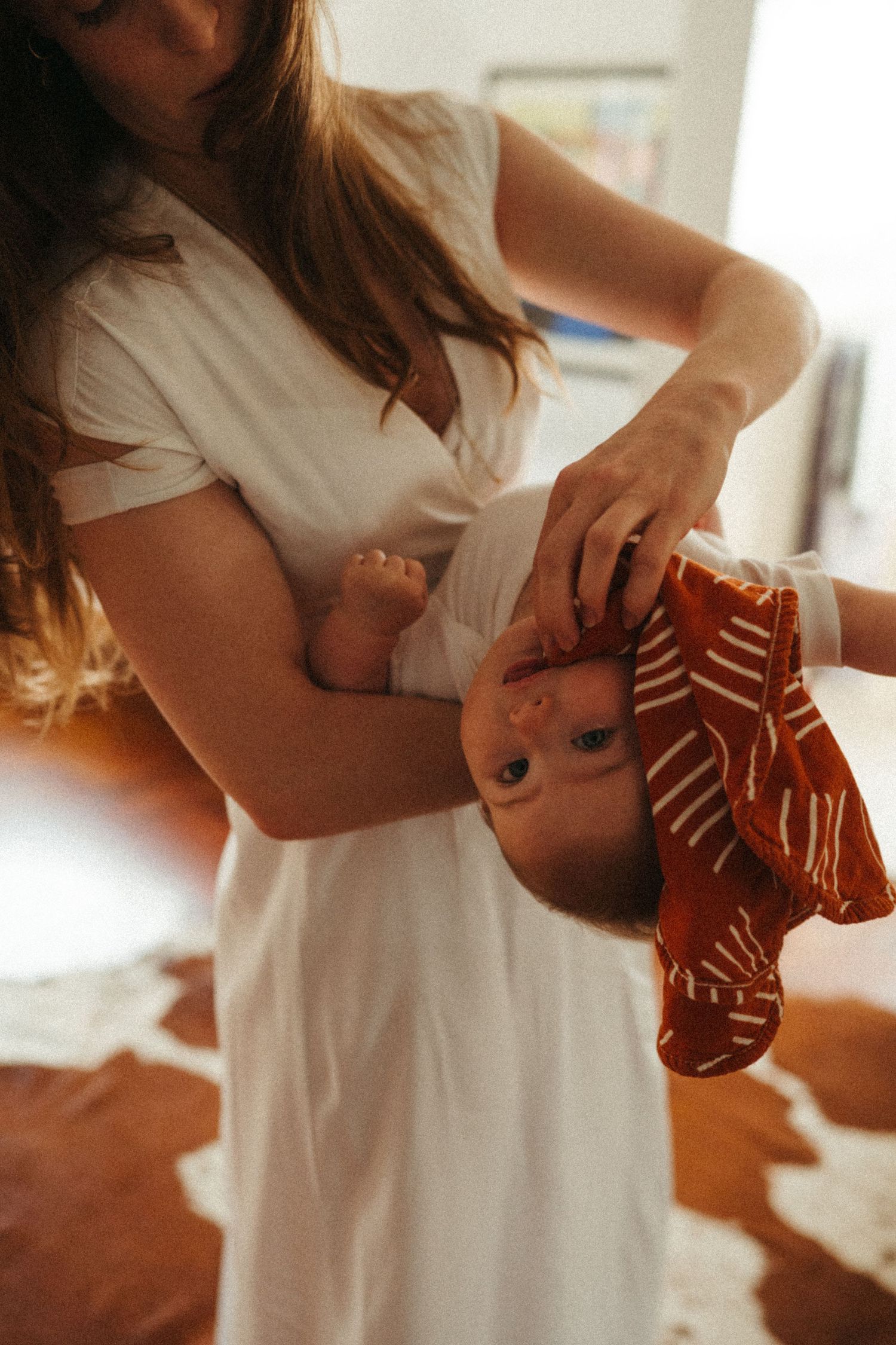 Family moment showing baby wearing striped socks during indoor playtime.