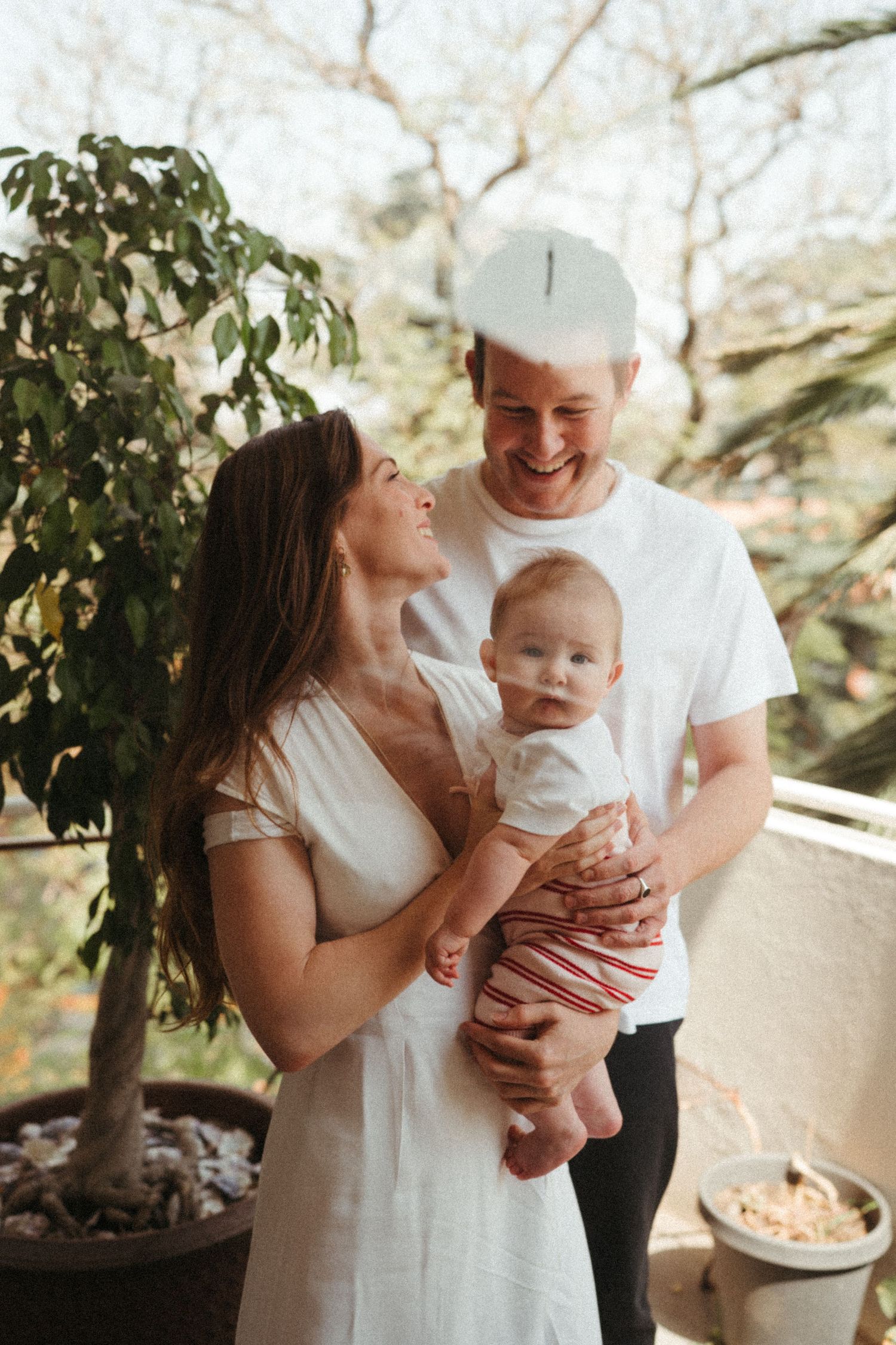 Family portrait sequence outdoors with white clothing and natural lighting.