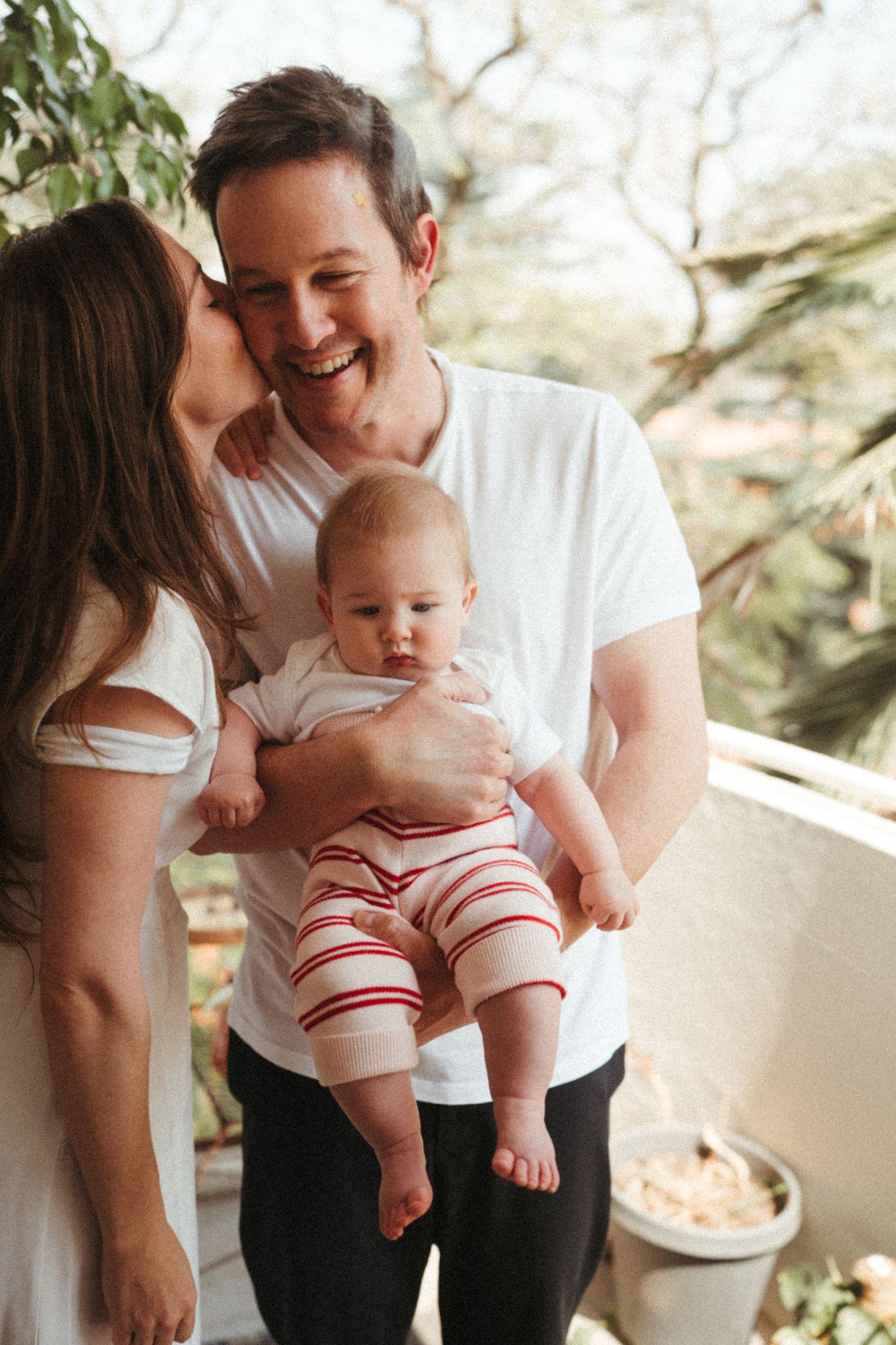 Casual family photos on a patio with potted plants in the background.