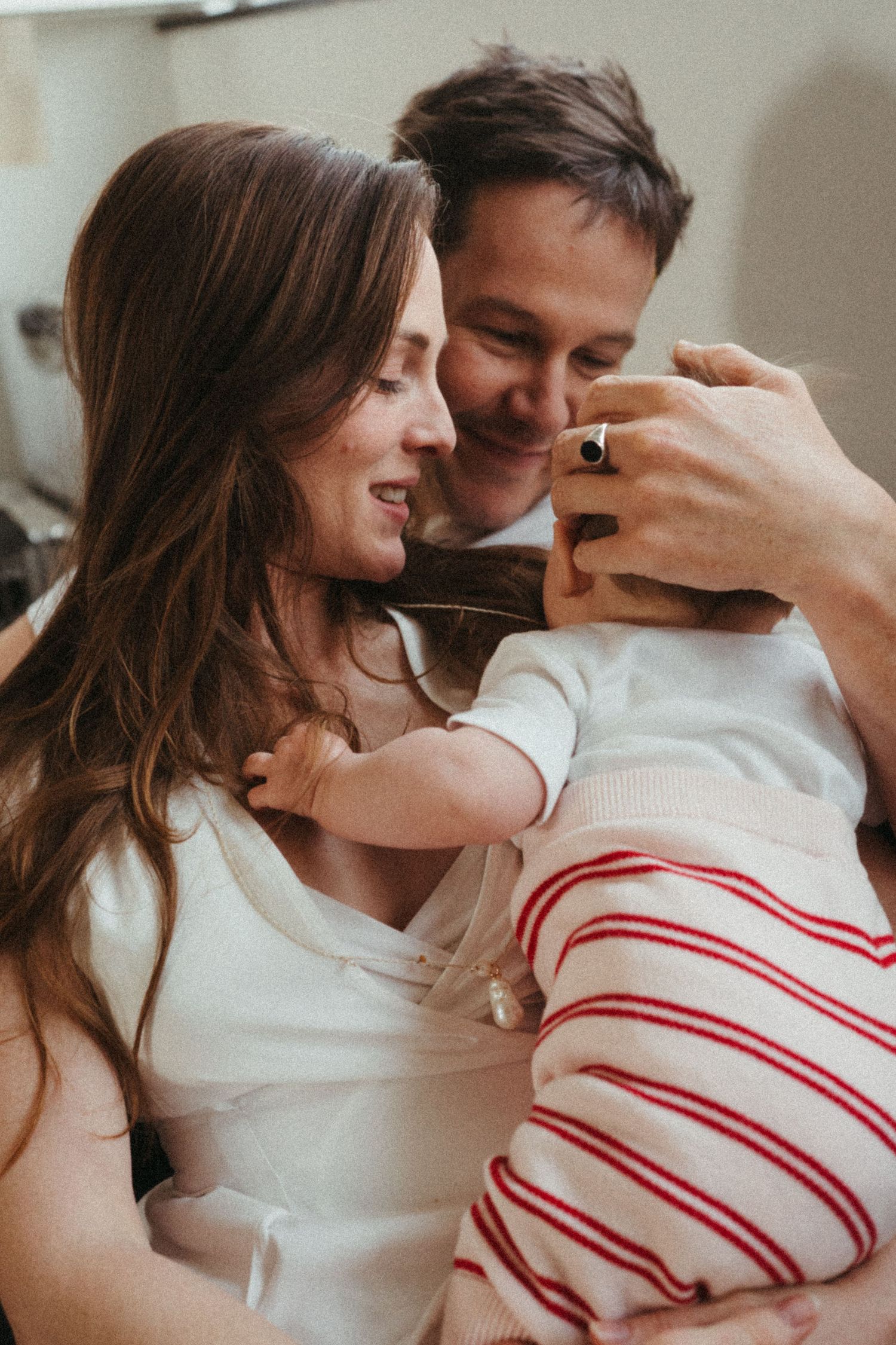 Couple sharing tender moments in casual white and striped clothing.