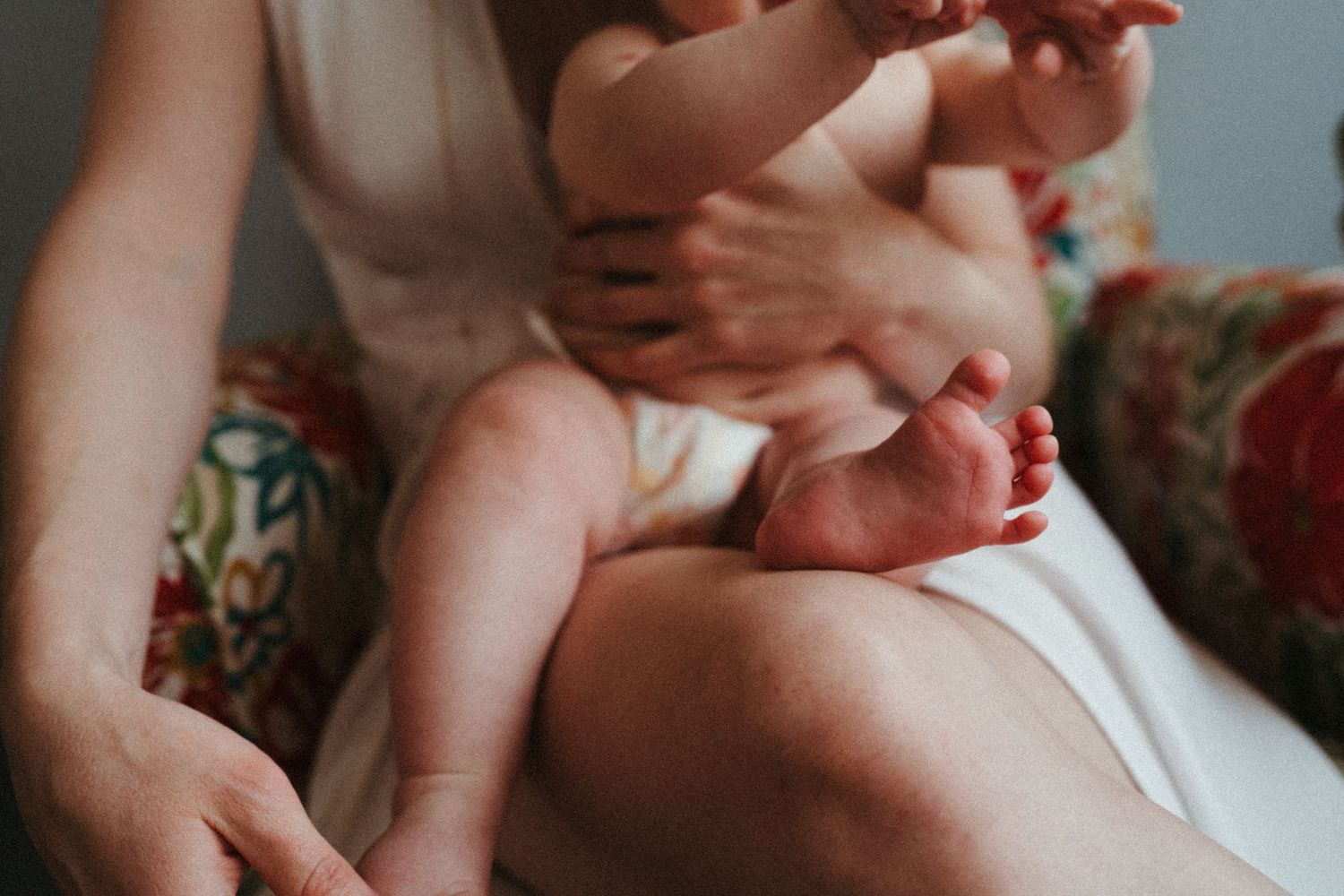 Parent holding and bonding with baby in soft natural light.