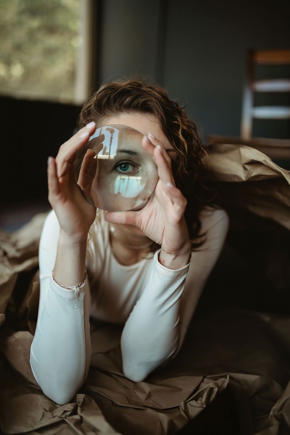 Creative portrait looking through a crystal ball creating a reflected eye effect. Bellevue studio, WA