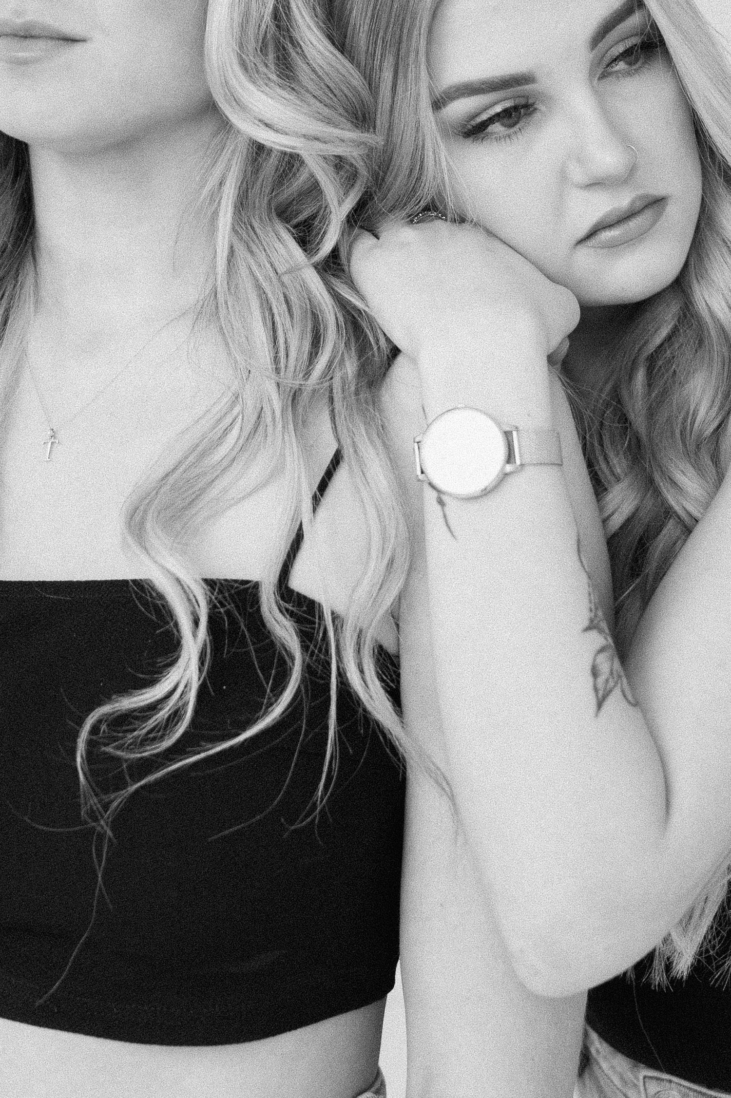 Black and white portrait showing elegant watch and blonde wavy hair details.