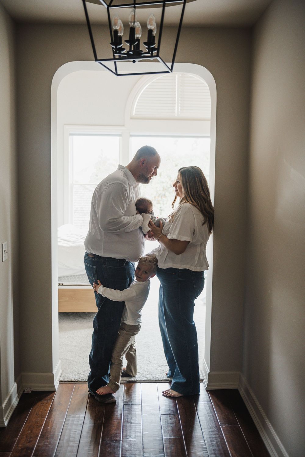 Candid family moments captured in a series of black and white photos showing interaction in an empty room.