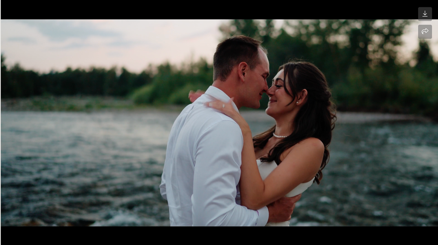 A romantic couple shares intimate moments by a scenic waterfront during sunset.