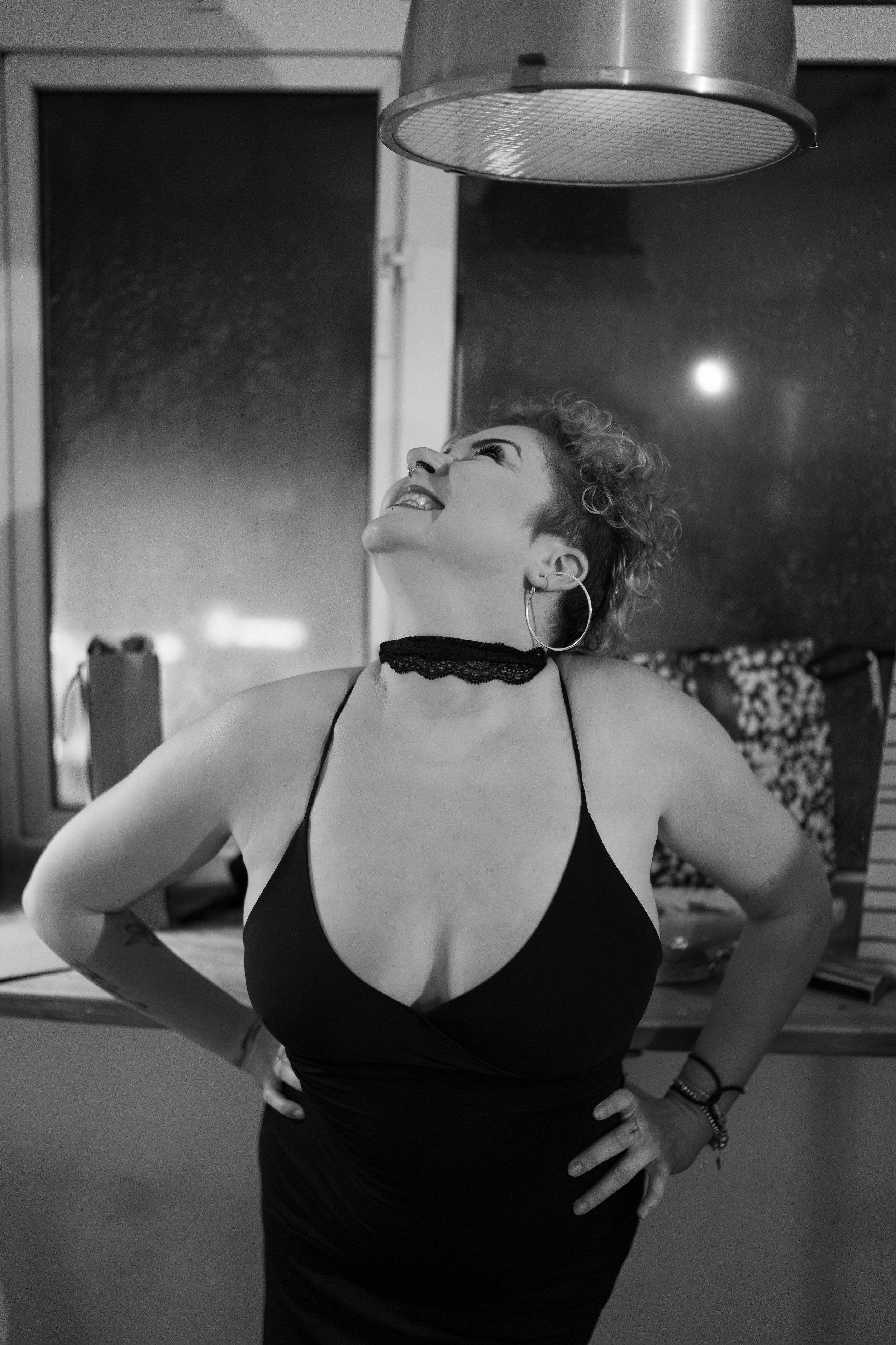 Black and white sequence of a person in a black top drinking from a glass in dramatic lighting.