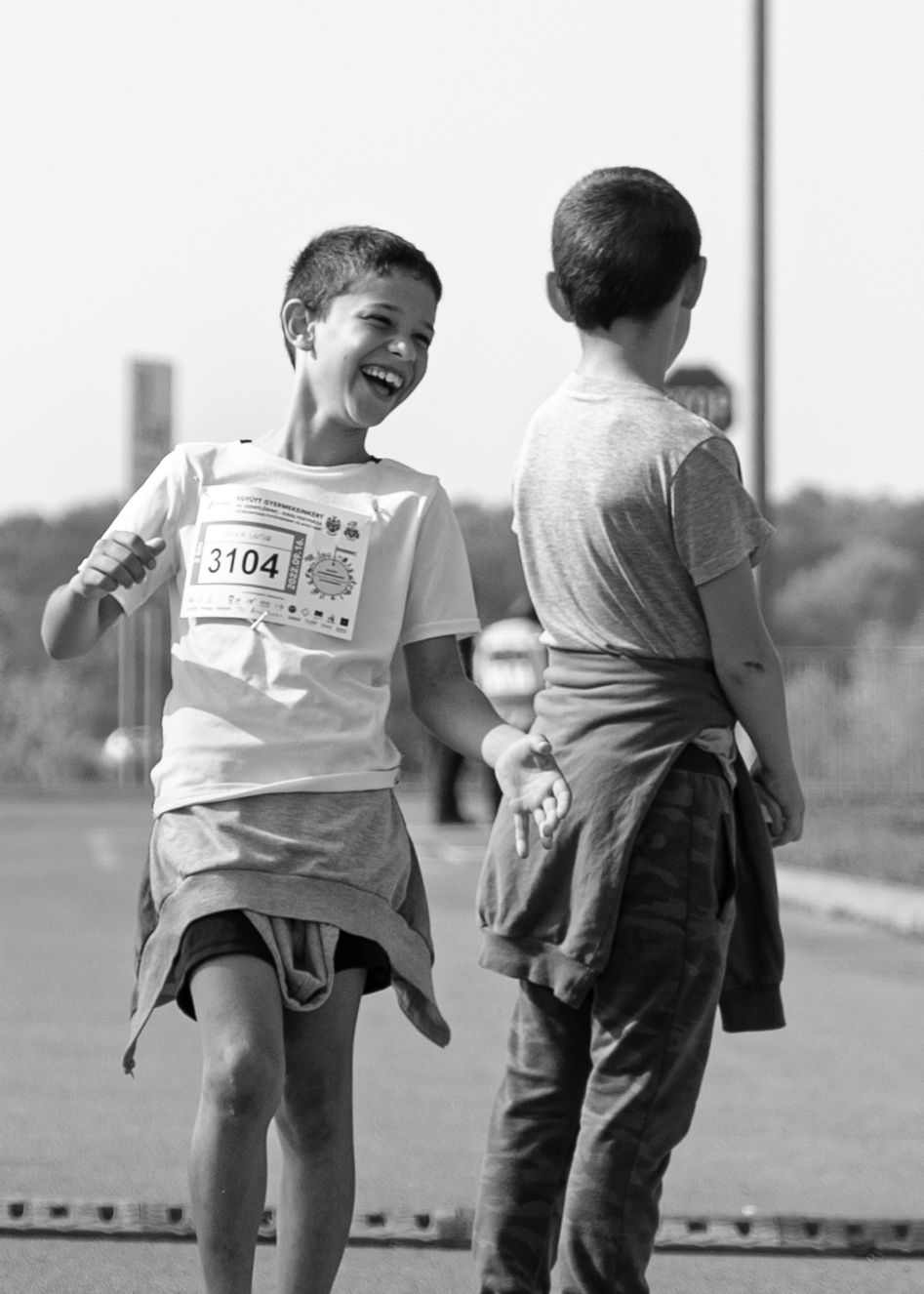 Young runner laughs joyfully during a race event.