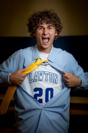 Student wearing light blue Lawton #20 jersey showing excitement and enthusiasm.
