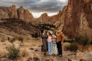 Dramatic desert landscape at Smith Rock State Park with towering rock formations and stormy skies overhead.