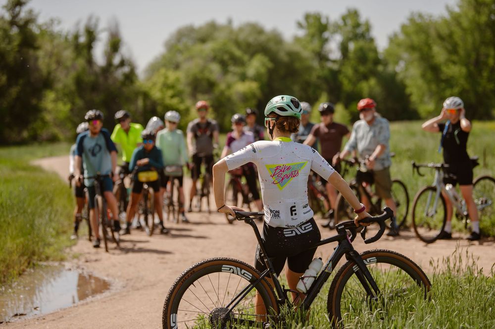 Cyclists riding in a group through a scenic rural road during a summer cycling event.