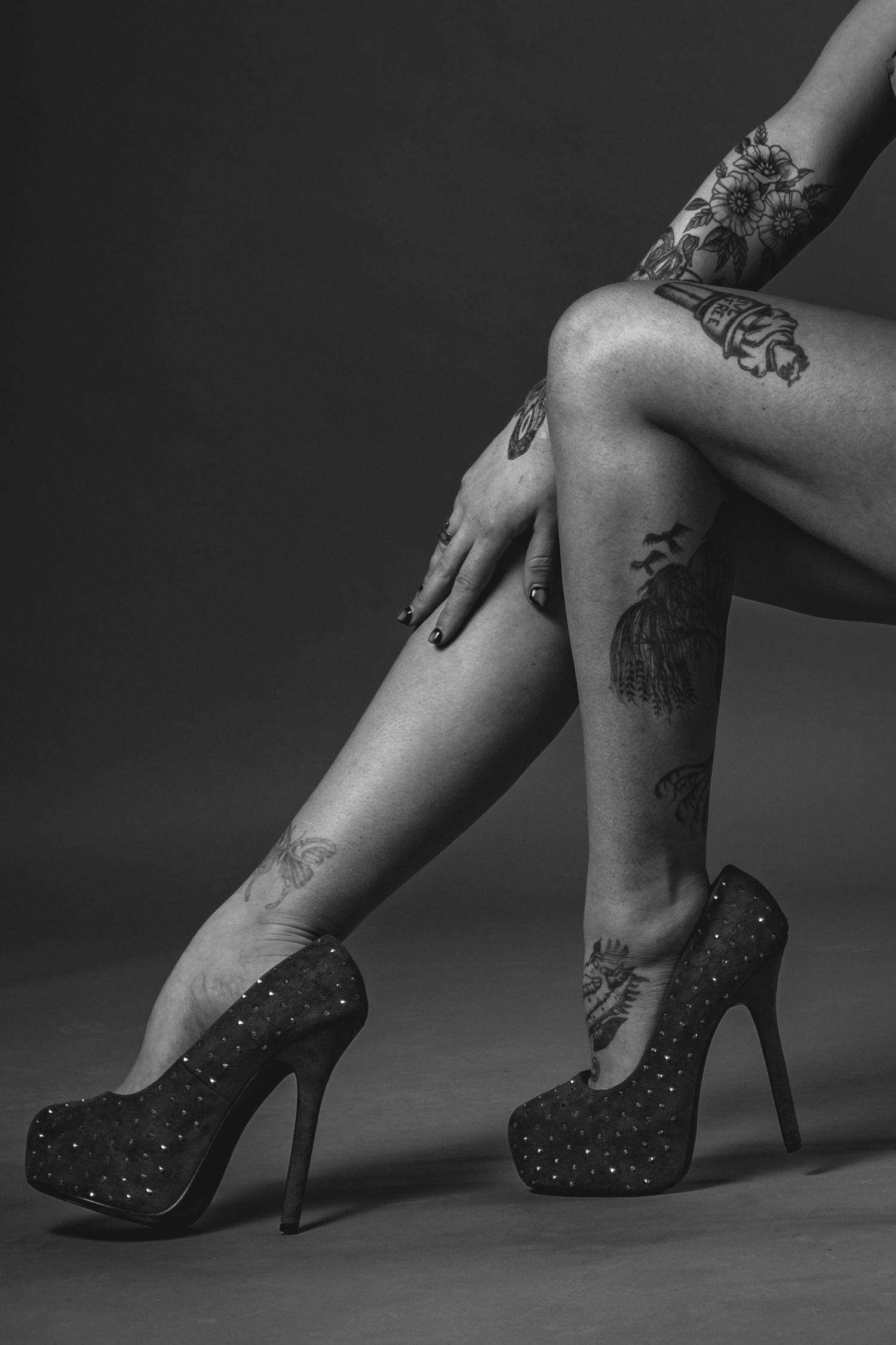 Dramatic black and white boudoir portrait with flowing fabric and artistic poses.