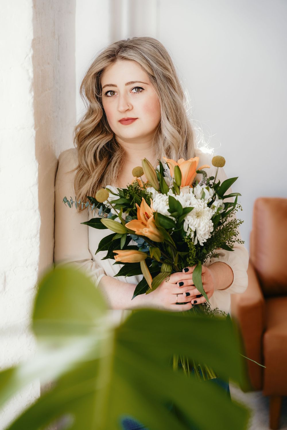 Portrait series with floral arrangement featuring lilies and white flowers against bright window.