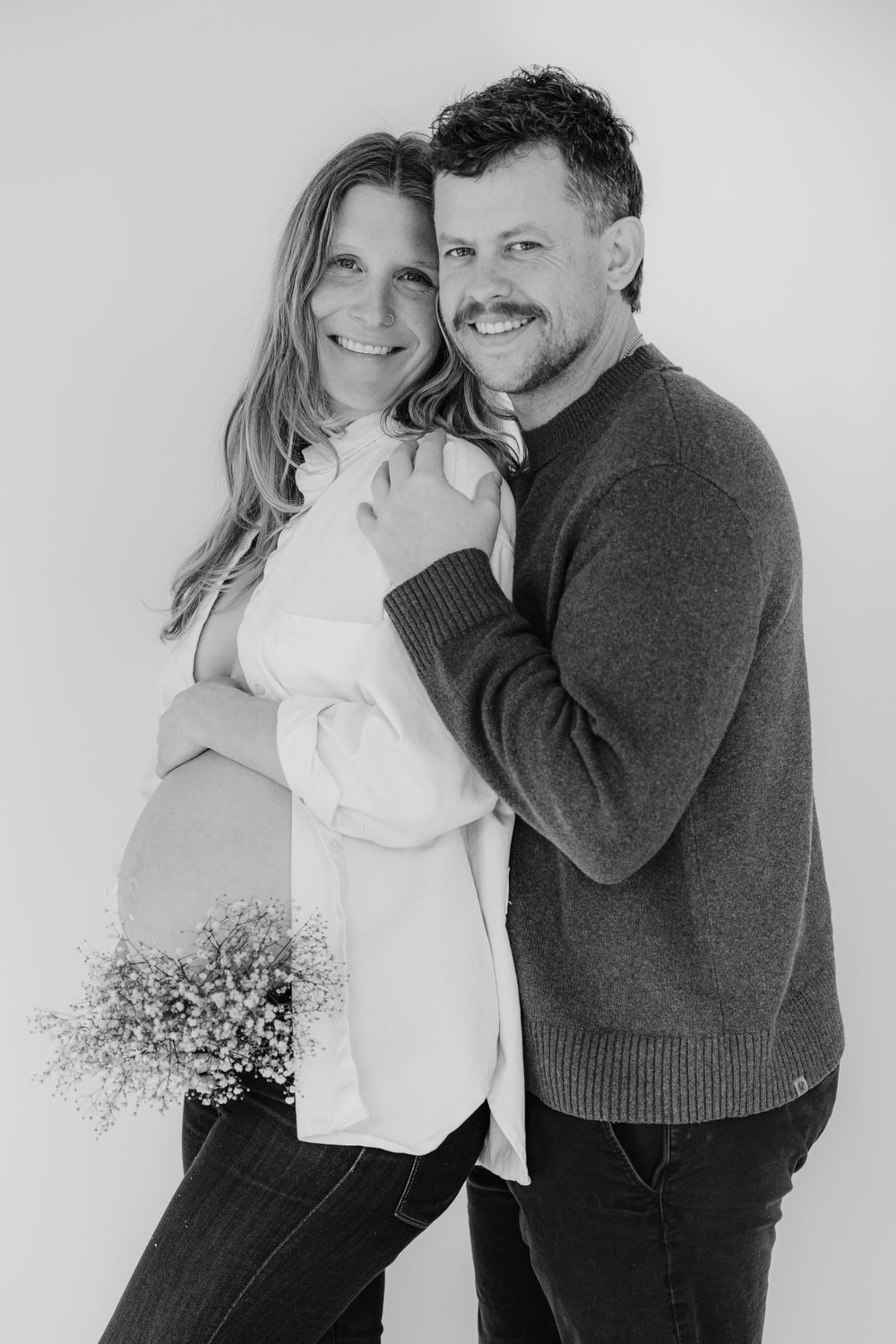 Black and white portrait series showing intimate moments between couple with baby's breath flowers.