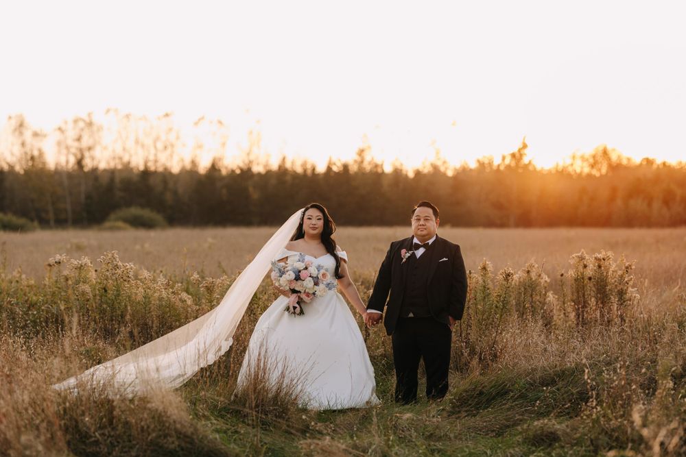 Wedding couple photographed in natural meadow setting during sunset.