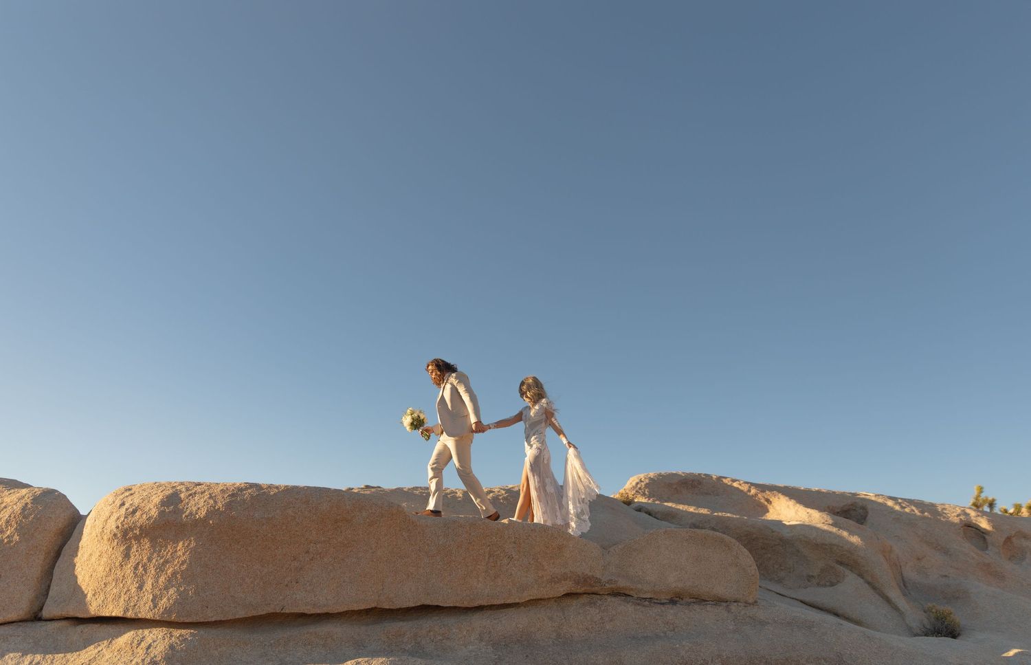 Orlando luxury wedding photographer couple walking hand-in-hand on the rocks.