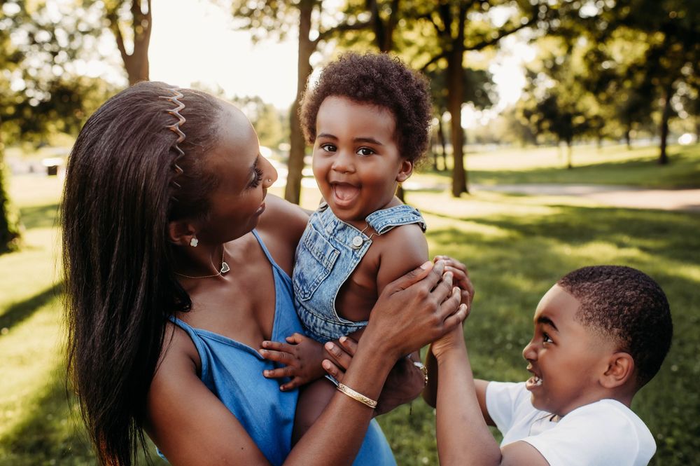 A loving family shares joyful moments together outdoors on a sunny autumn day in the park.