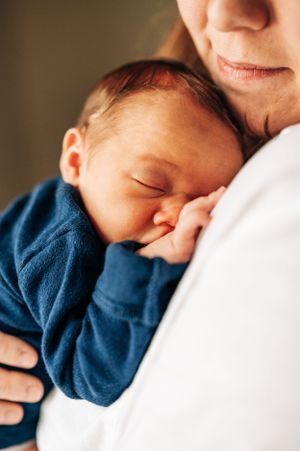 Close-up of sleeping baby in blue outfit resting peacefully.