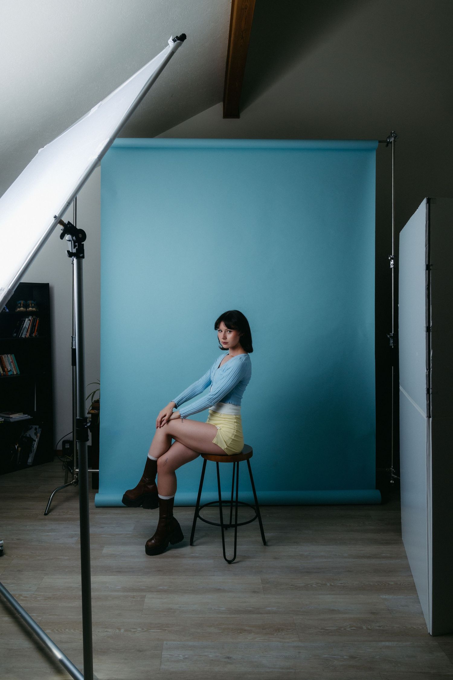 Artistic photo series showing figure in blue top and yellow skirt in minimalist room setting.