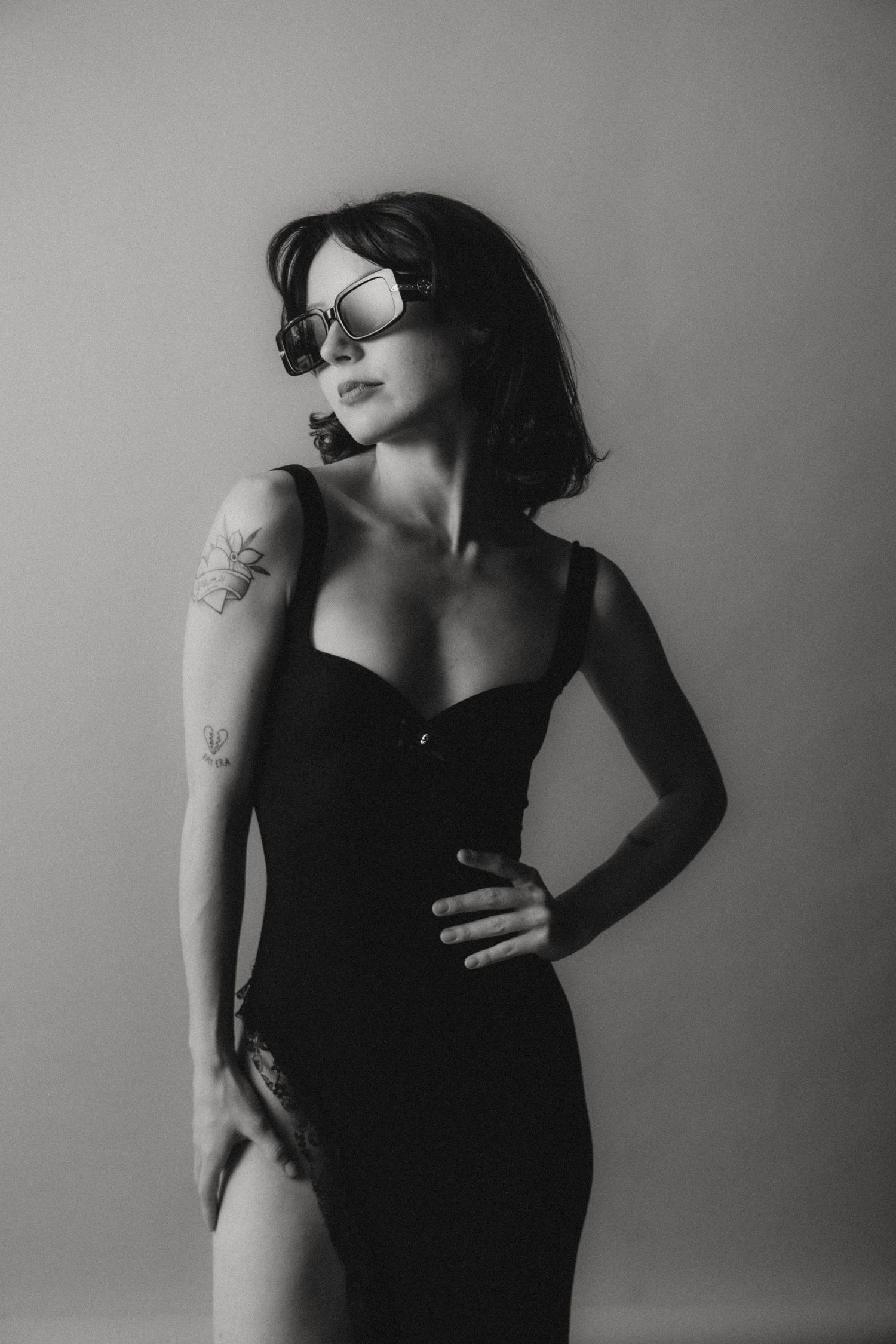 Dramatic black and white fashion portraits showing person in dark sleeveless dress.