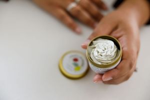 Chicks and roses calendula product photo of woman of color holding jar of cream in hand in Maple Valley, WA