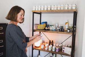 Maple Valley, WA Acupuncture shelf of recommended supplements for clients lifestyle product female acupuncturist looking at herb supplement