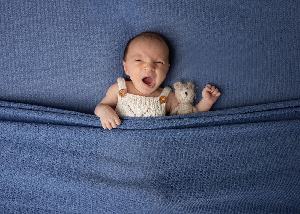 A sequence of close-up shots showing someone emerging playfully through blue fabric in a peekaboo style.