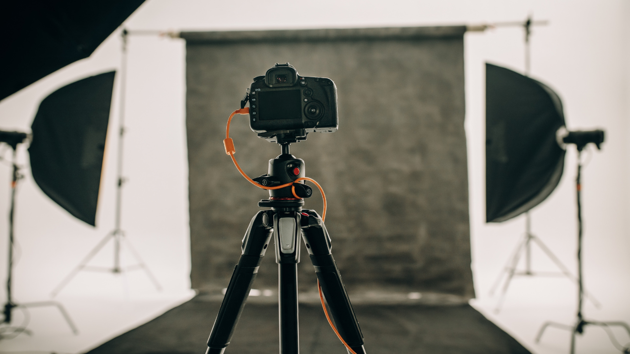 Professional camera setup on tripod in photography studio with lighting equipment.