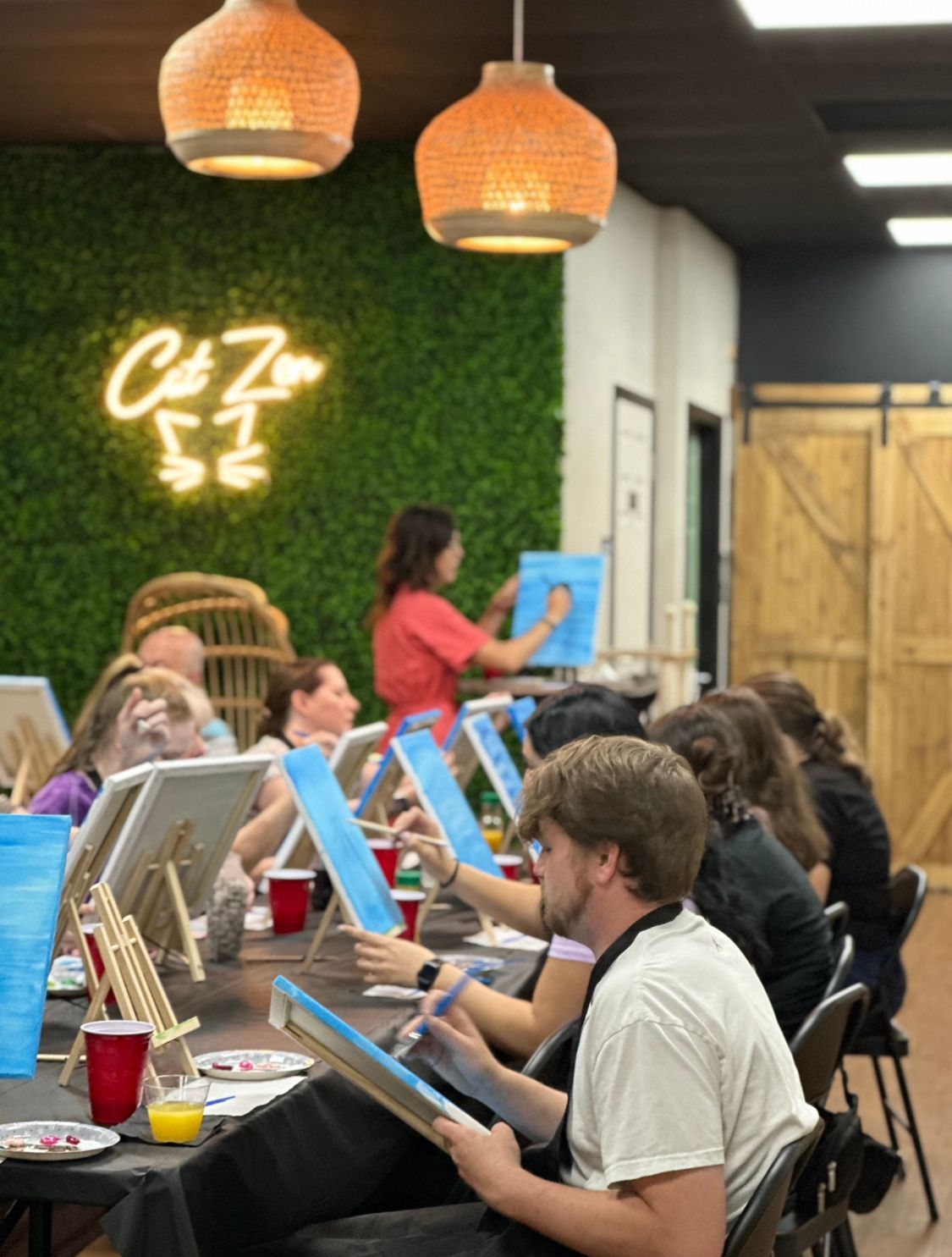 Art class participants painting at tables at Cat Zen Cafe and Lounge in St. Charles, MO.