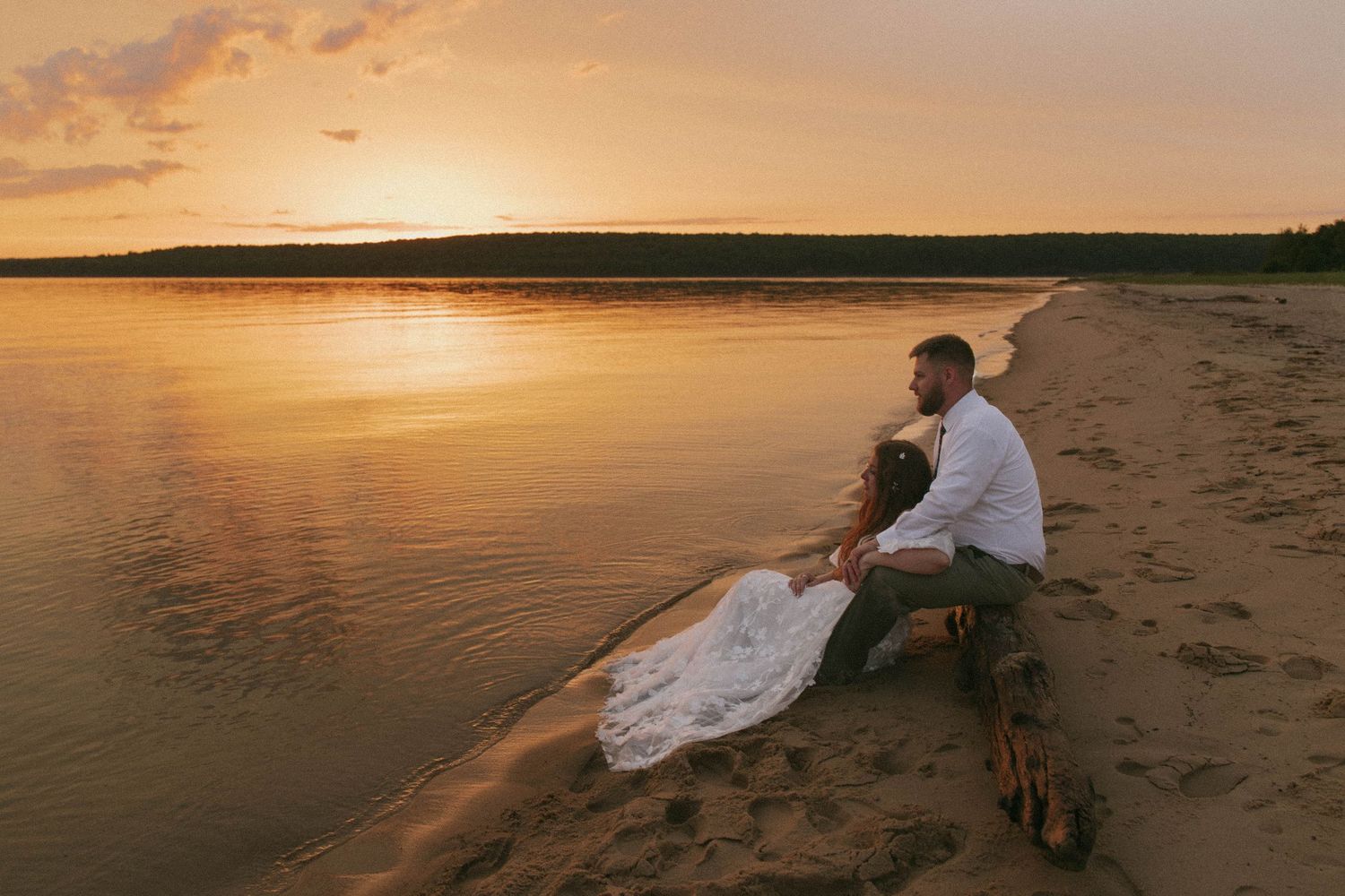 Romantic waterfront sunset photo of couple with flowing veil.