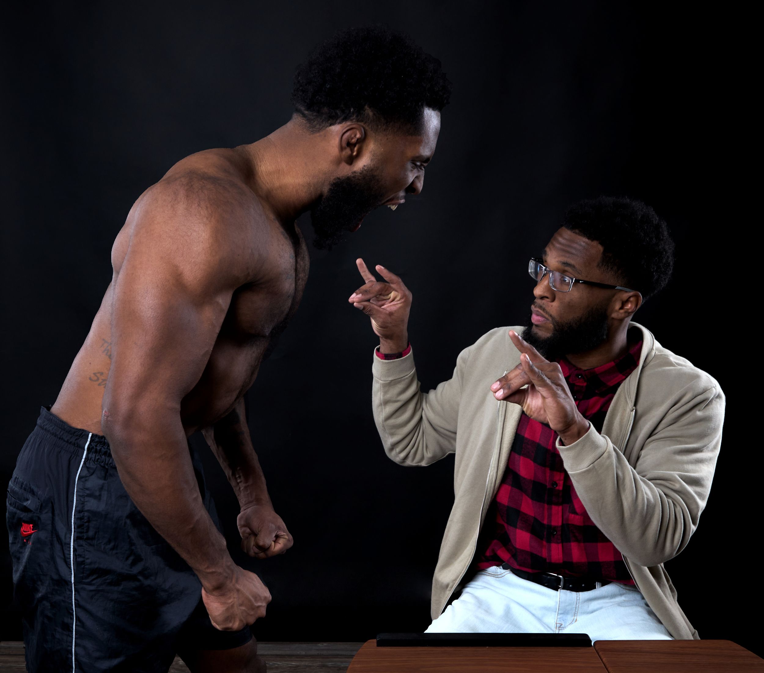 Dramatic action sequence of staged fight scene against dark background.