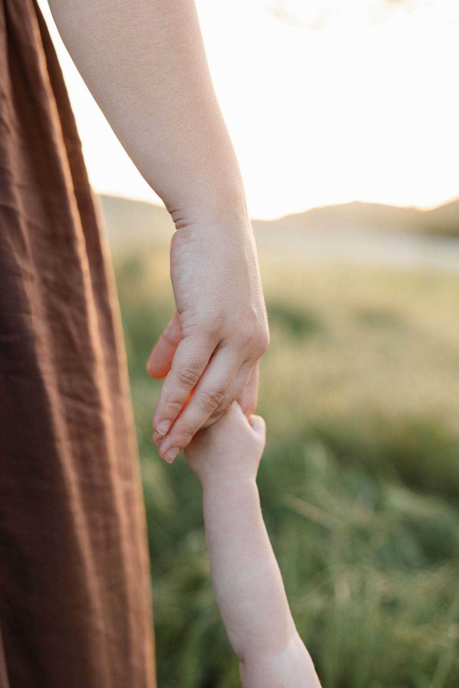 Little girl holding her mom’s hand during a family session in Newbury Park, California