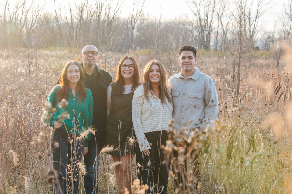 Family portrait session in a serene field with tall grass during golden hour.