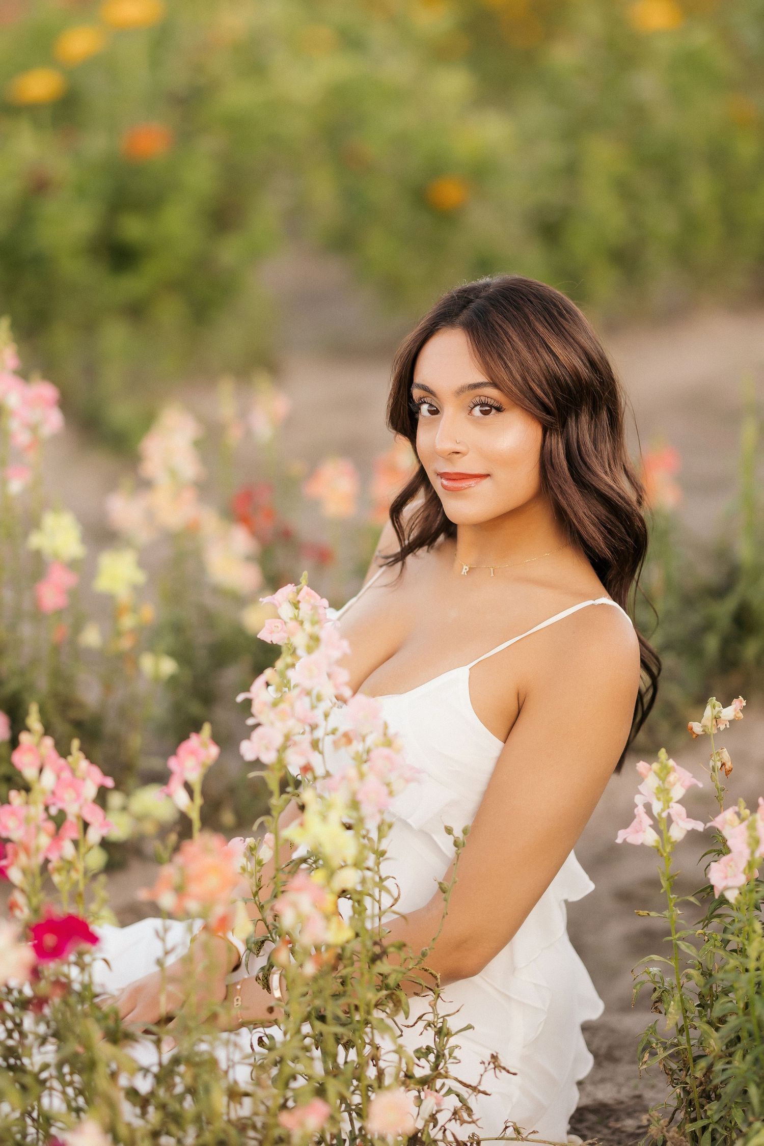 A series of outdoor portrait photos in a garden with blooming pink and orange flowers on a sunny day.
