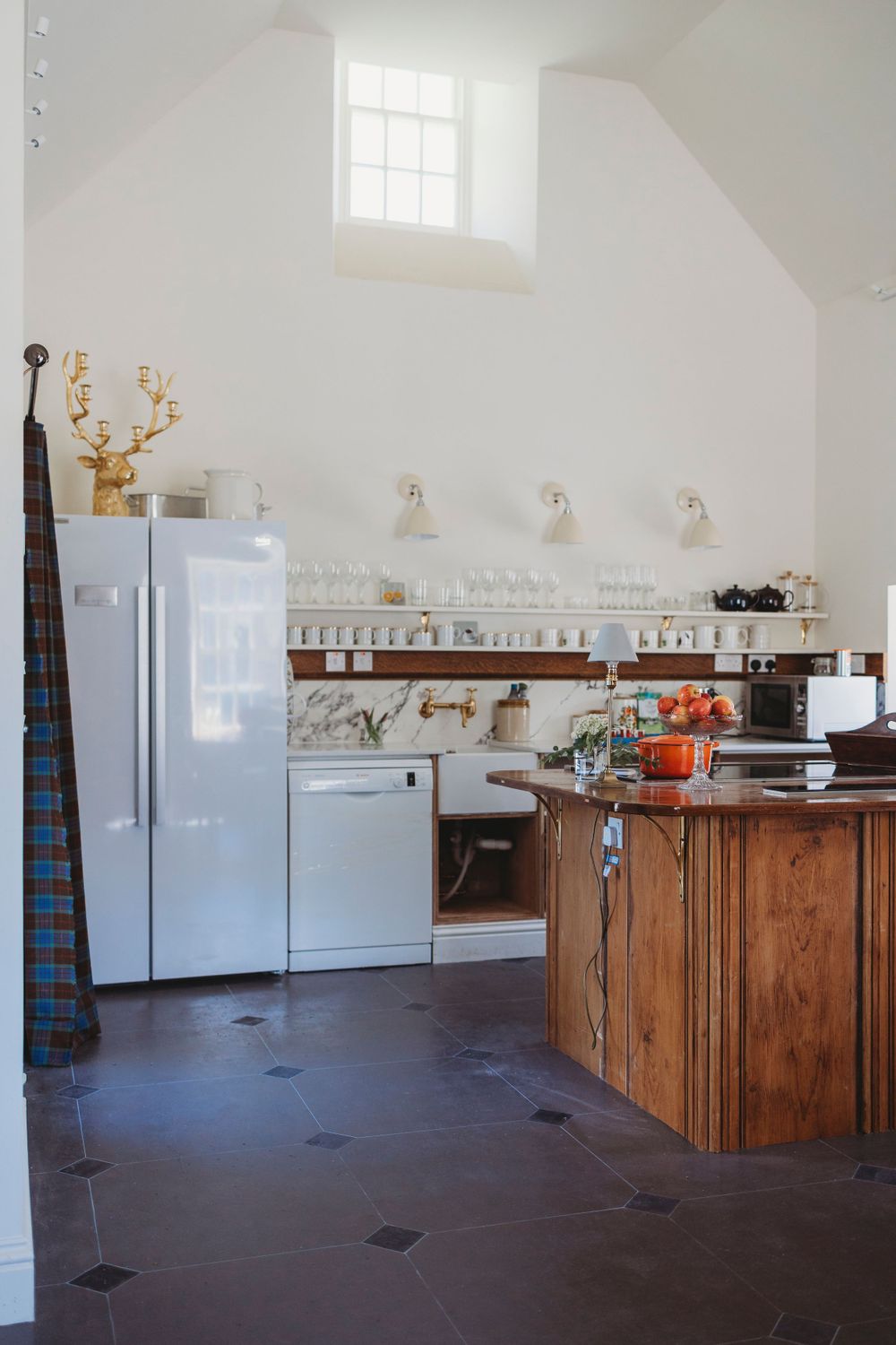 Modern white kitchen with wooden counters and stainless steel appliances.