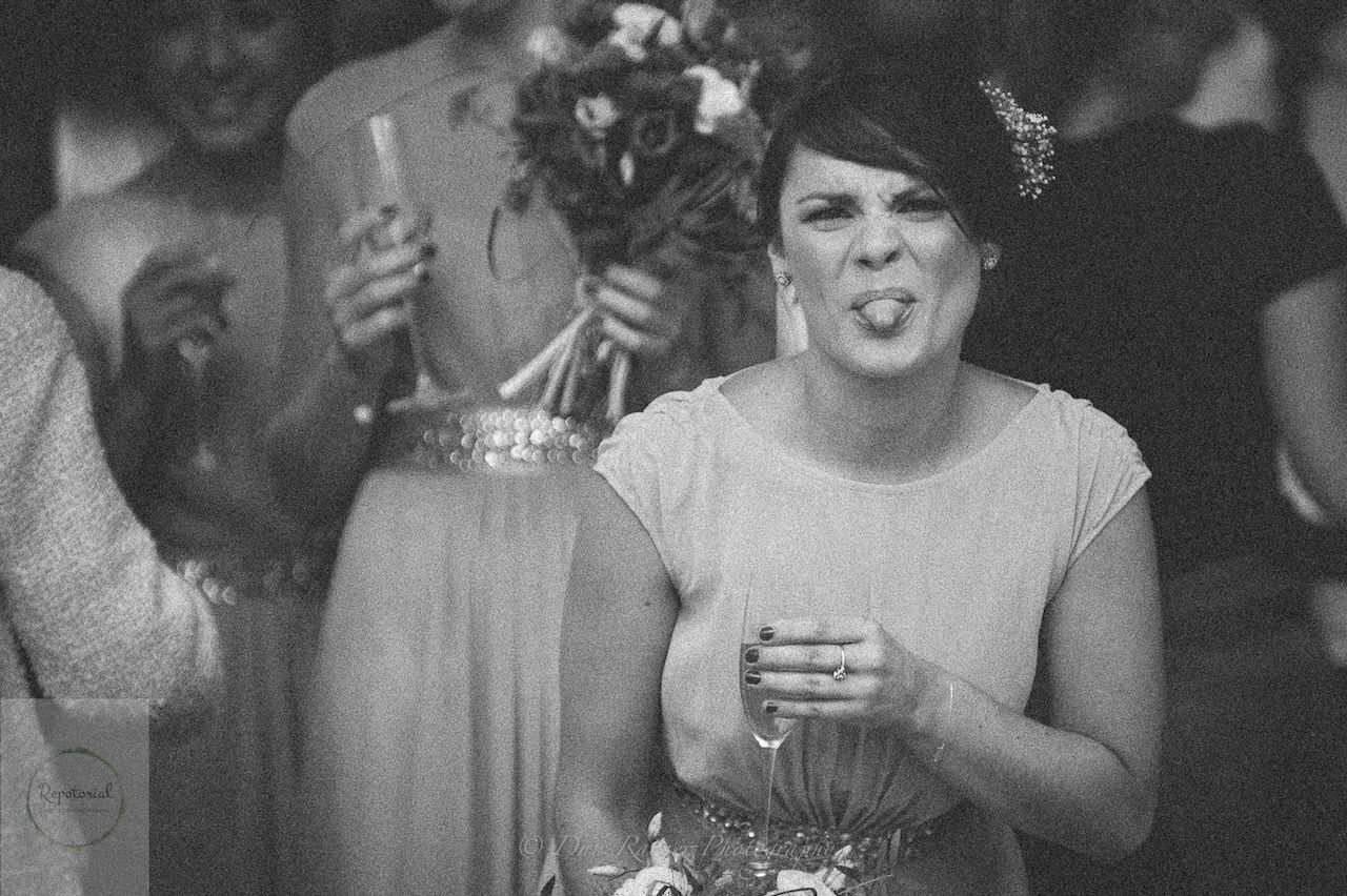 Reportage detail shot of bridesmaid sticking her tongue out when realising she was being photographed