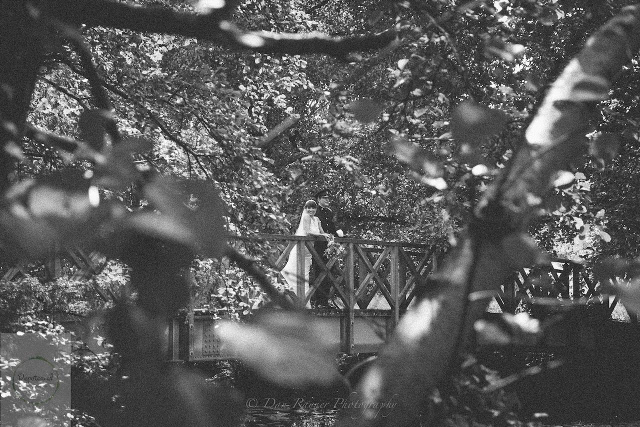 Wedding reportage photo of bride and groom enjoying a moment alone after the ceremony on a wooden bridge