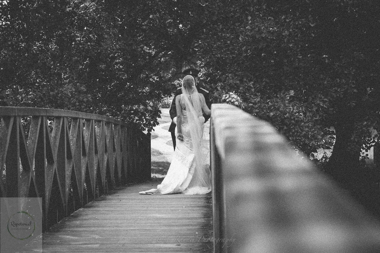 Wedding reportage photo of bride and groom enjoying a moment alone after the ceremony on a wooden bridge