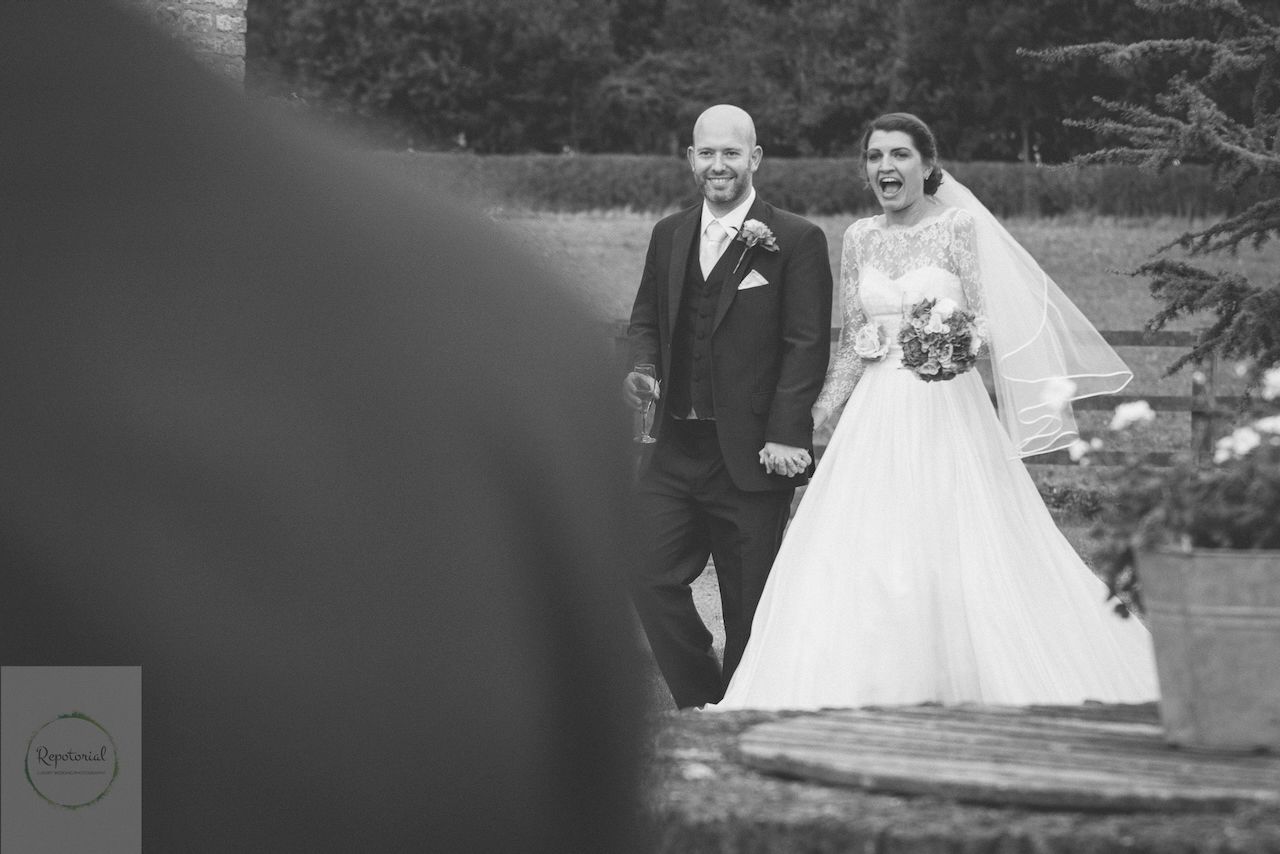 Bridge and groom enjoying the wedding reception captured in candid style. Stratton Court Barn