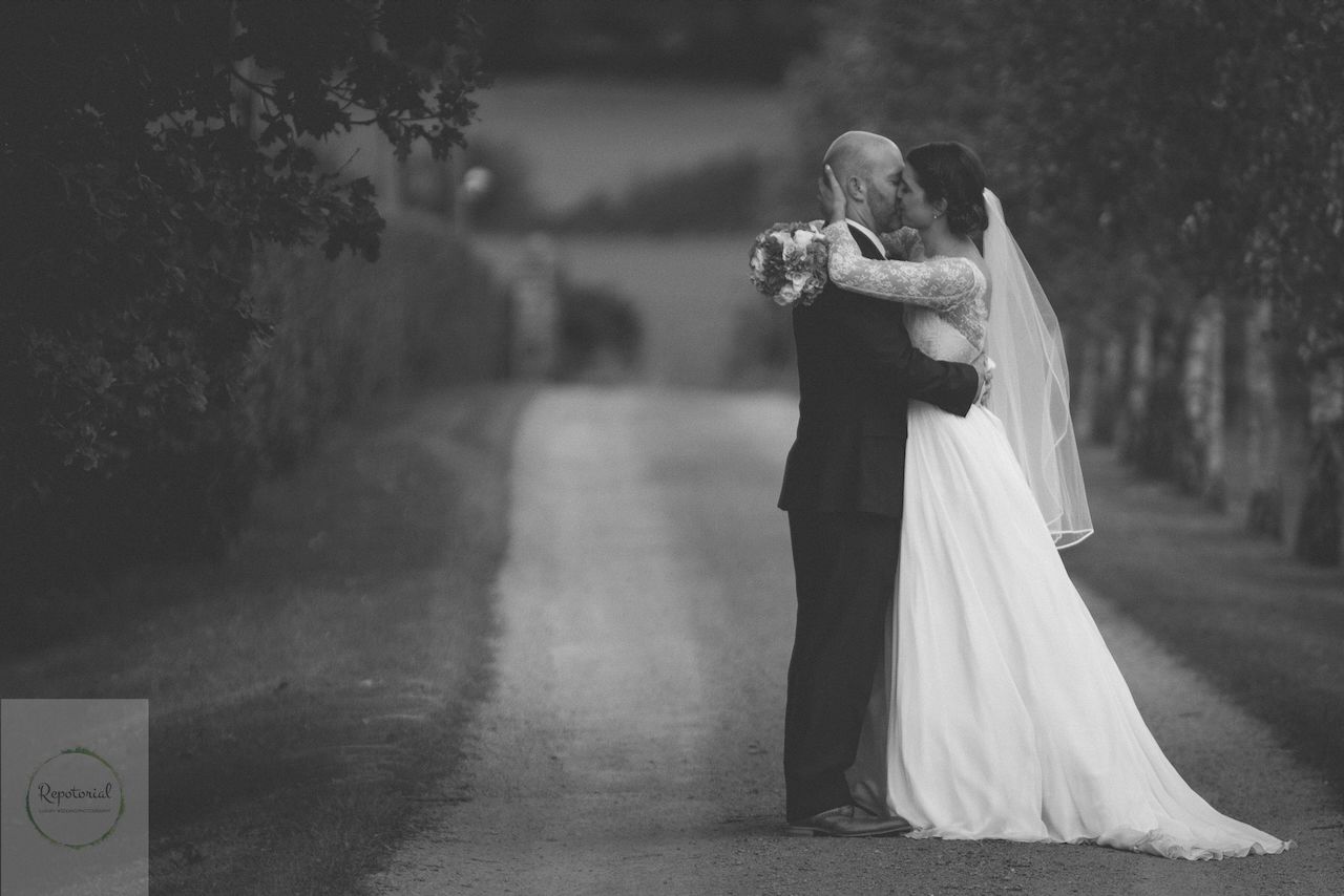 wedding editorial portrait of bride and groom embracing on drive