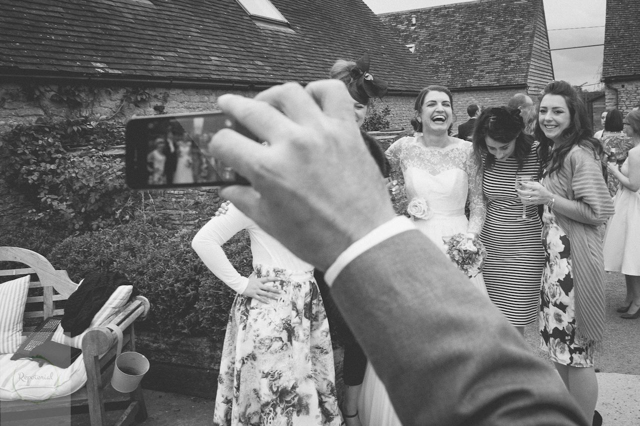 Editorial bridal portrait of a bride and friends in black and white enjoying the wedding reception. Stratton Court Barn