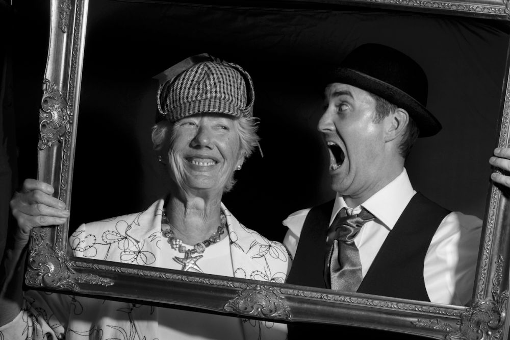 Wedding reportage photo of guests having fun in a pop up Photo Booth