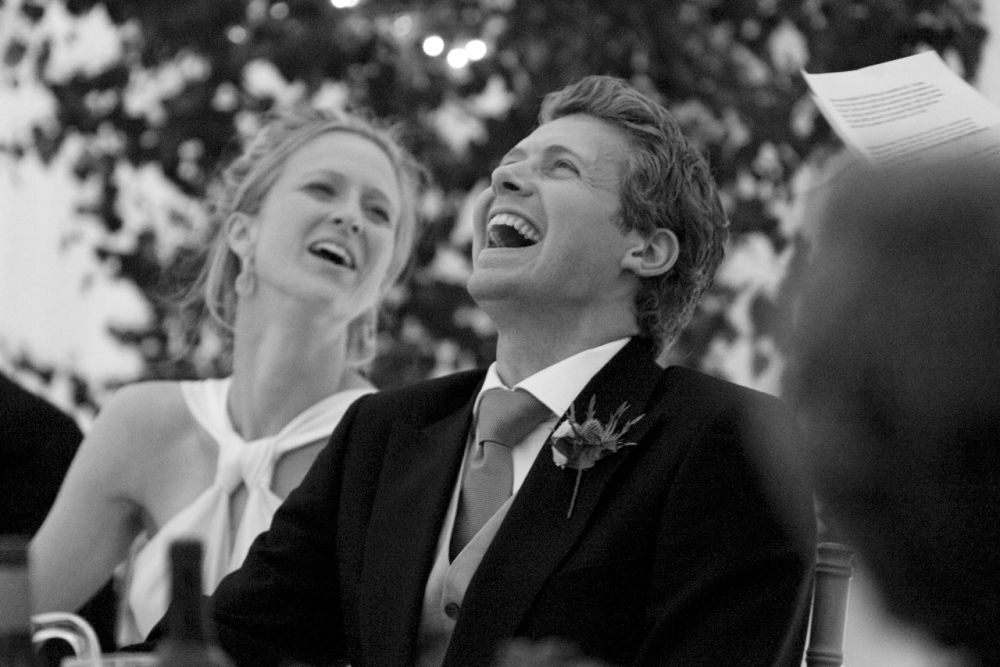 Reportage detail shot of bride and groom laughing during wedding speeches