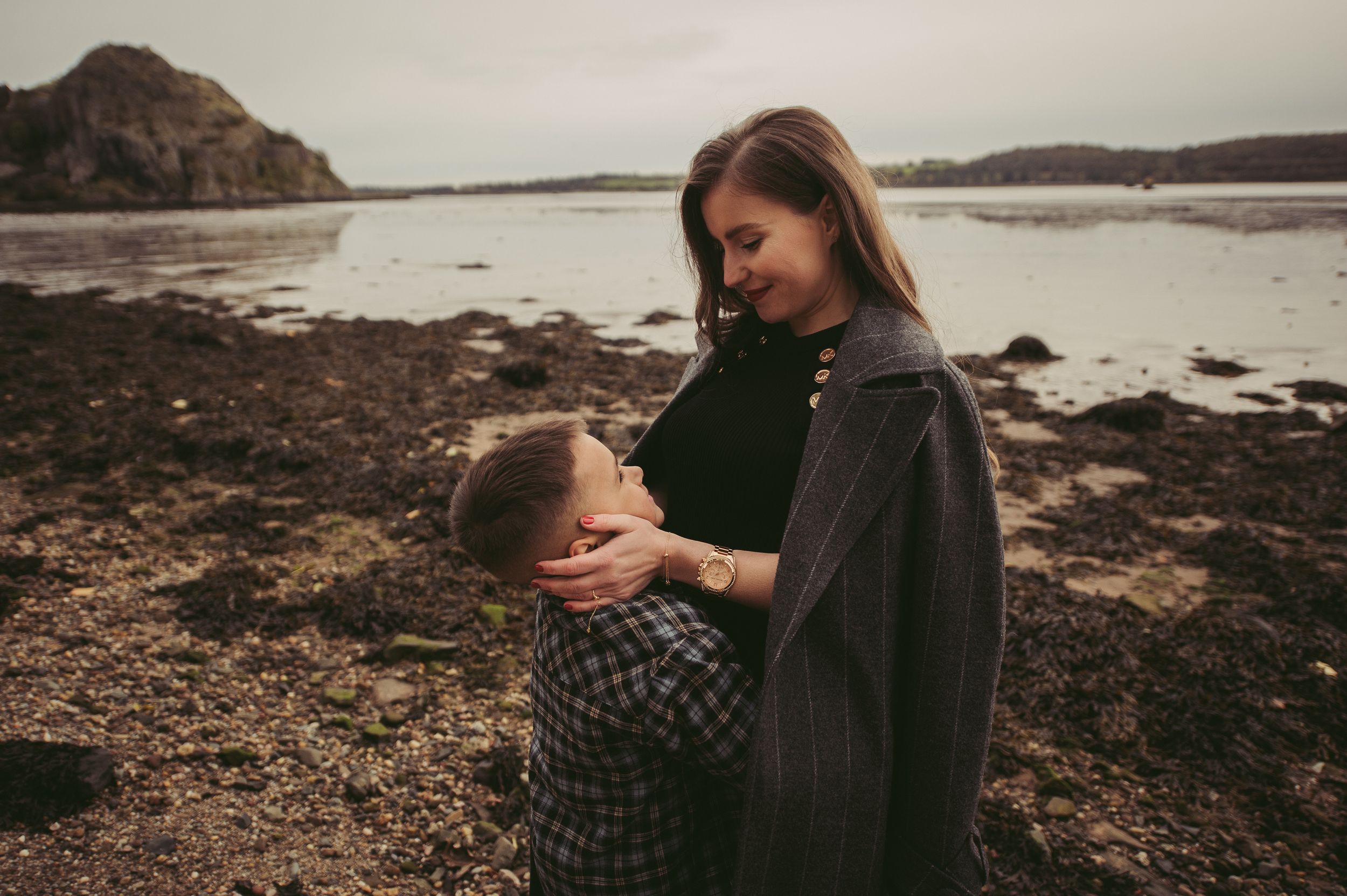 Candid photo of a mom hugging her young son outdoors