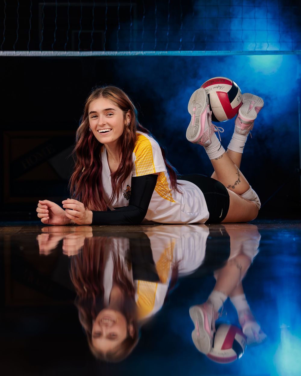 Palo Verde Volleyball player laying down on court with blue smoke and reflection Tucson, AZ