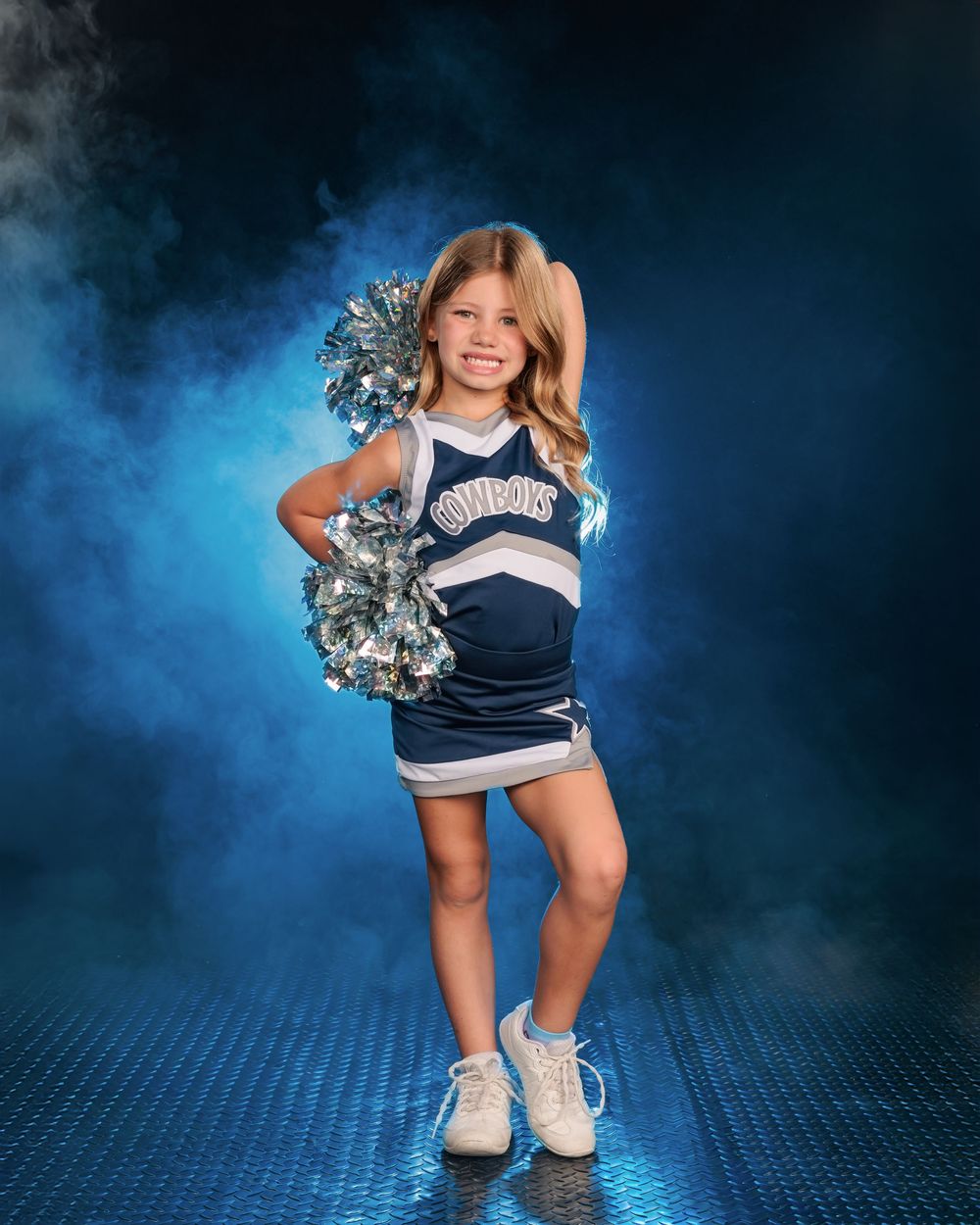 Tanque Verde cowboys cheerleader posing with poms and blue smoke Tucson, AZ