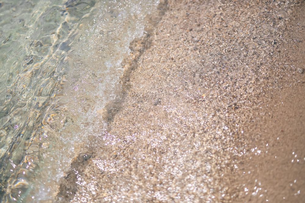 Textured surface showing fine, granular particles in a beige and grey pattern.